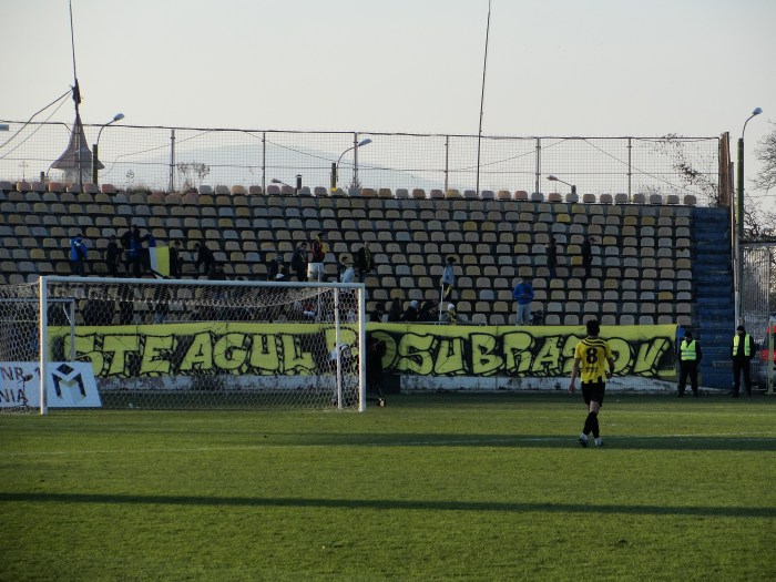Steagul Roşu Braş"opt". Puştiul clubului, Vlad Olteanu, care de la patru ani bate mingea în tricoul galben-negru se îndreaptă (pentru ultima oară?) să dea mână cu băieţii din galerie. 